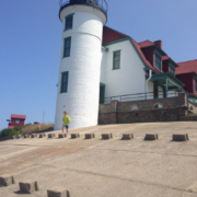 A kid in front of a lighthouse, one of the many attractions in Northern Michigan.